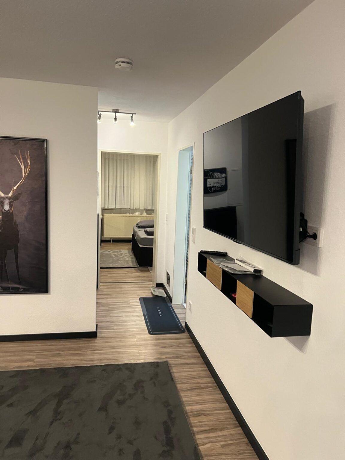 Hallway with TV and a view into the bedroom