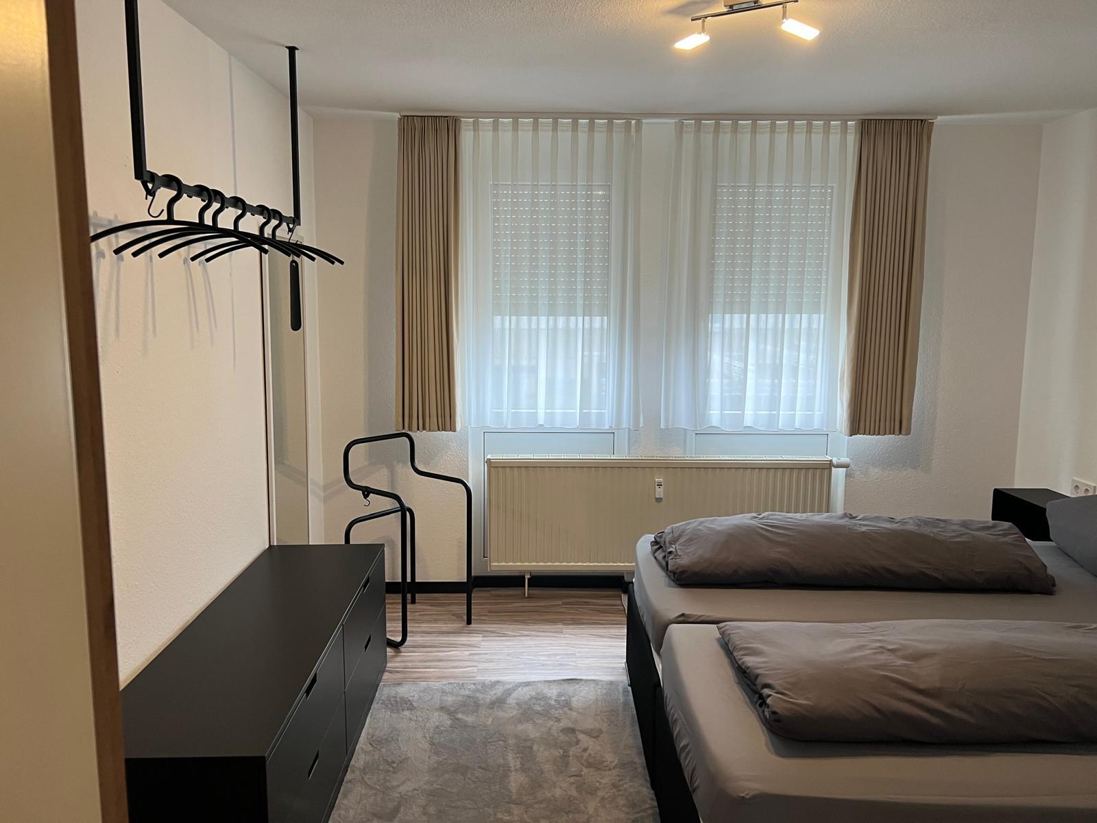 Bedroom with chest of drawers, clothes rail and windows
